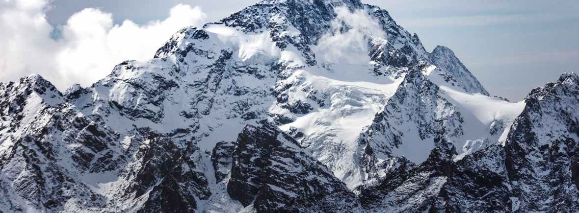 snow covered mountain under cloudy sky